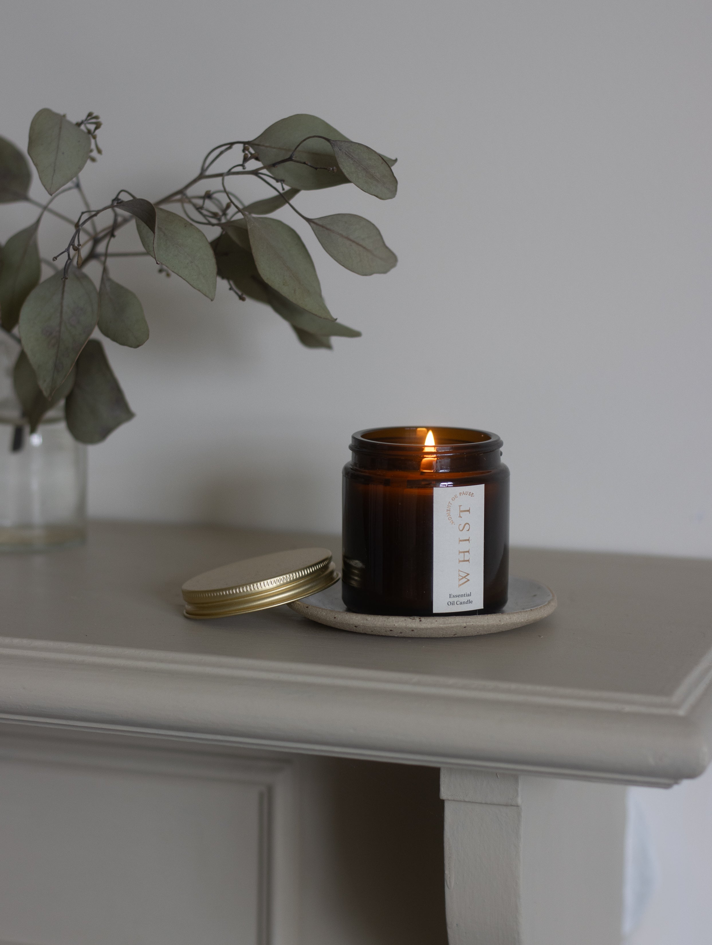 an amber jar candle on a fire mantle